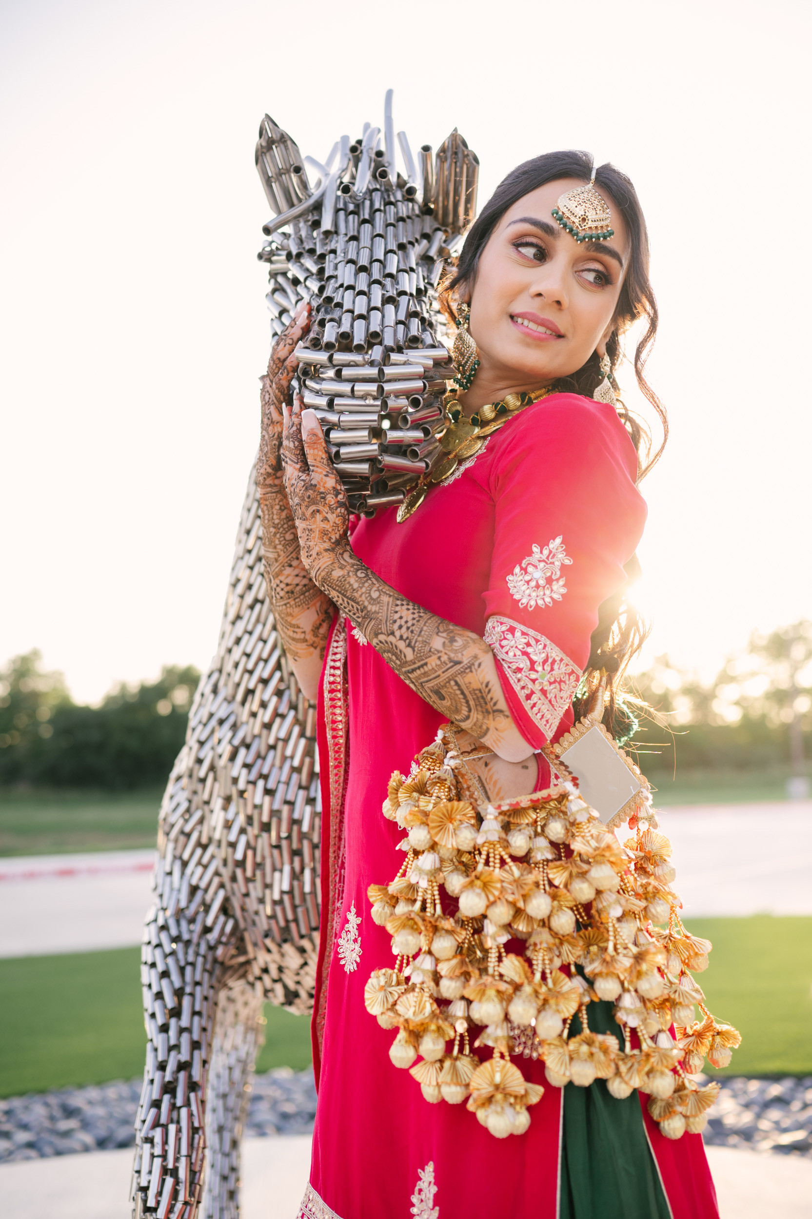 Solo bridal portrait of Anita beside metallic horse sculpture at Alexis Event Venue