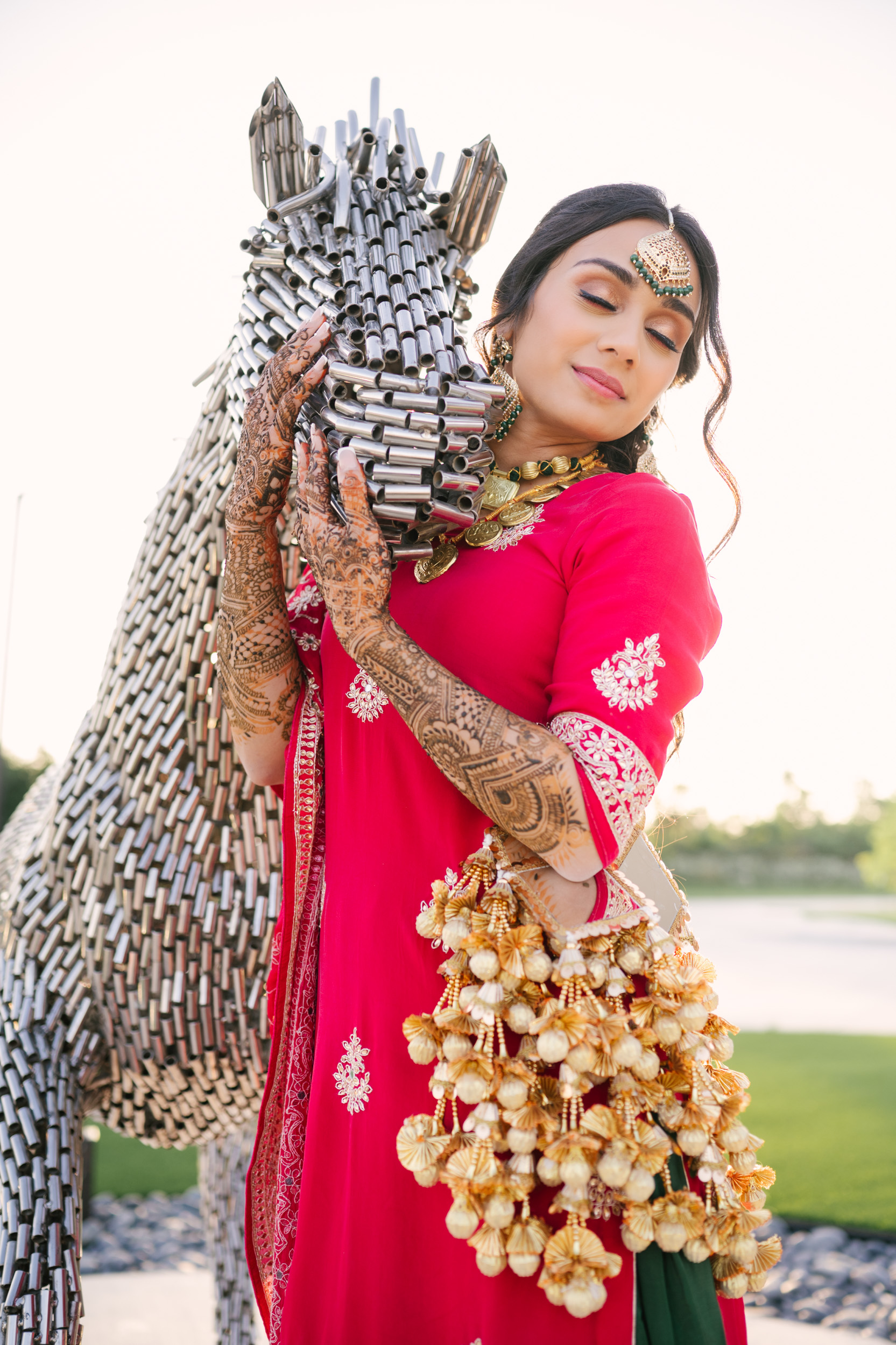 Solo bridal portrait of Anita beside metallic horse sculpture at Alexis Event Venue