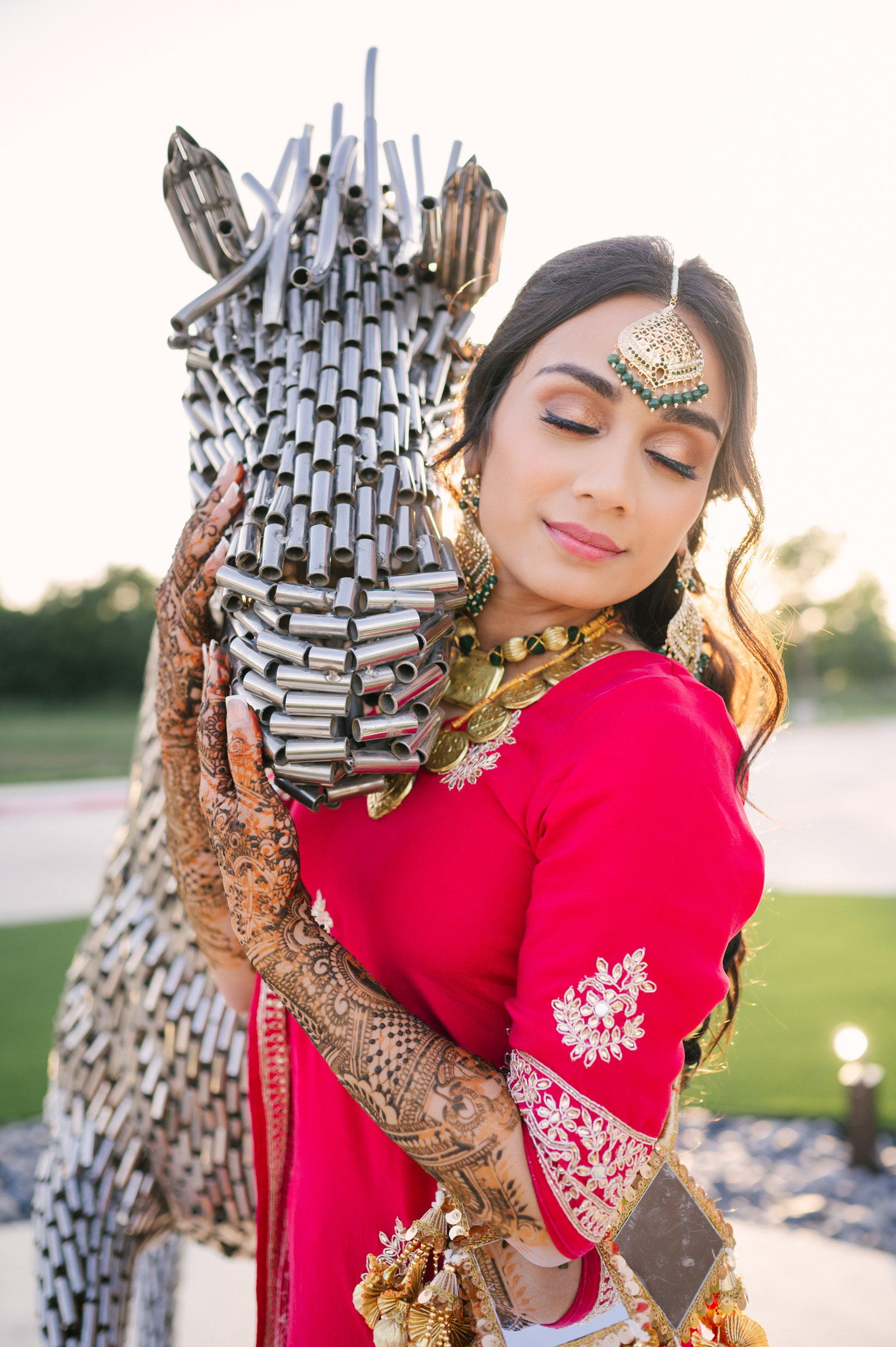 Solo bridal portrait of Anita beside metallic horse sculpture at Alexis Event Venue