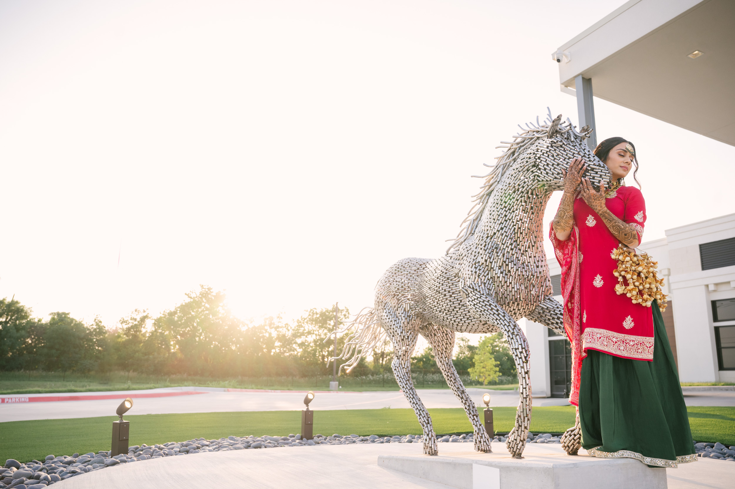 Solo bridal portrait of Anita beside metallic horse sculpture at Alexis Event Venue