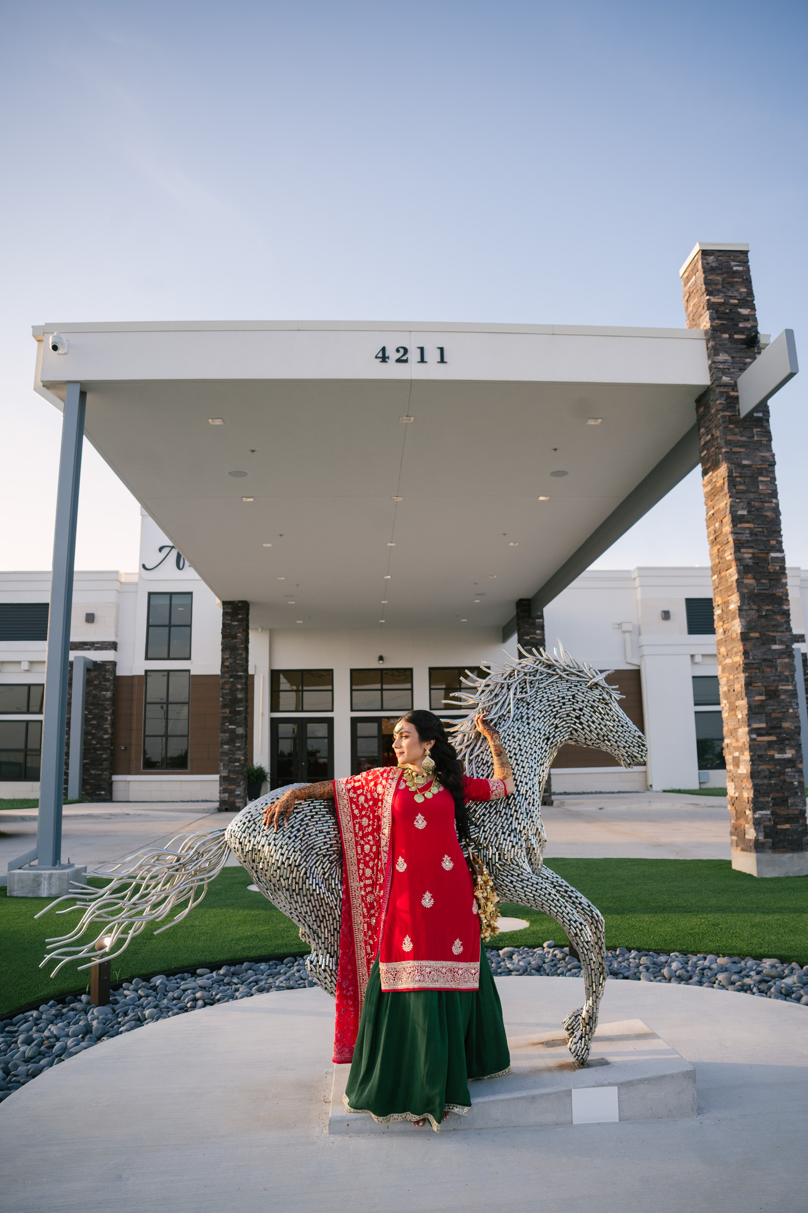 Solo bridal portrait of Anita beside metallic horse sculpture at Alexis Event Venue